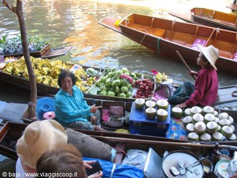 Floating market: women selling bananas, coconuts and fruit from wooden boats