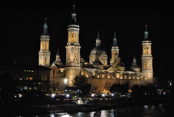 Illuminated Basilica of Our Lady of the Pillar at night by the Ebro river