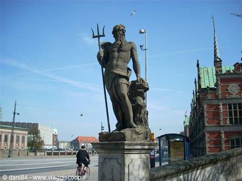 Stone statue of Neptune with trident in front of Copenhagen stock exchange