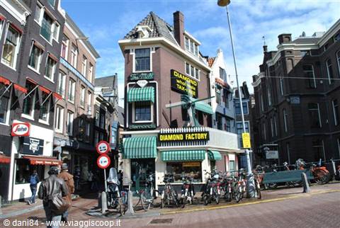 Corner building with yellow and green signs of a diamond factory, Amsterdam, parked bicycles
