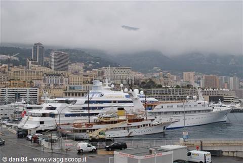 White yachts moored at Monaco harbor under a cloudy sky