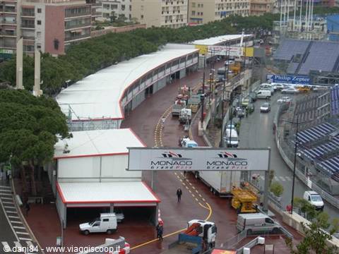 Monaco Grand Prix paddock: wet streets, grandstands and trucks among buildings