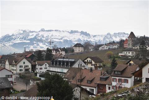 Red village rooftops beneath the snow-capped Swiss Alps