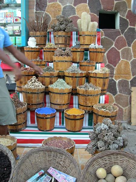 Wooden baskets with spices, dried herbs and fruits at a market stall