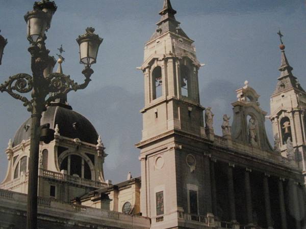 Bell tower and dome of Almudena Cathedral behind a wrought-iron lamppost