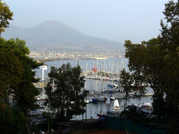 White sailboats in Naples harbor, Mount Vesuvius hazy in the background