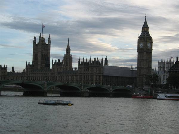 Big Ben and Westminster Palace by the Thames with bridge and boat