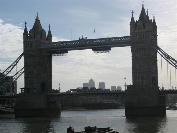 Tower Bridge in London, stone towers over the Thames against cloudy sky