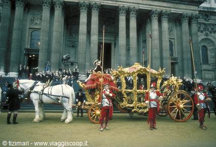 Golden state coach with white horses and red guards before the palace columns