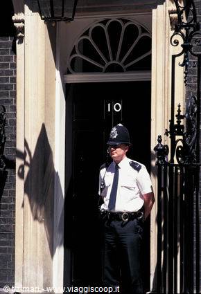Police officer guarding the black door of 10 Downing Street, London