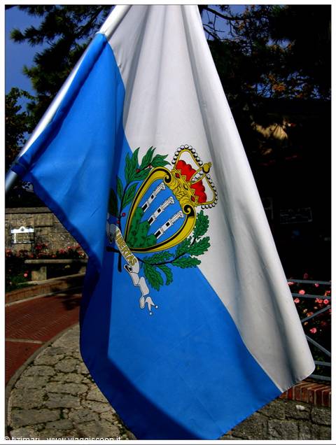 San Marino flag waving in the wind with the three towers coat of arms