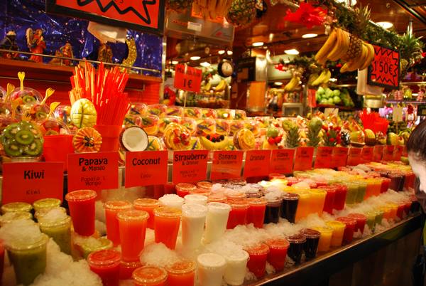 Colorful fresh fruit juice cups on ice at La Boqueria market