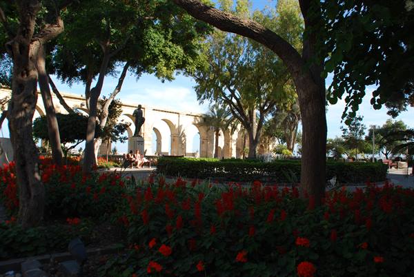 Lower Barrakka Gardens in Valletta: red flowers, stone arches and statues