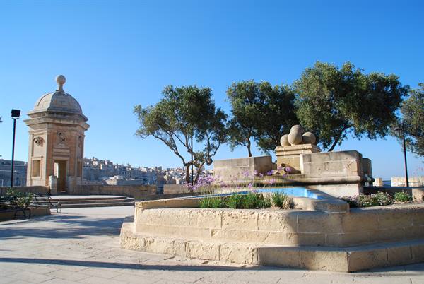 Lower Barrakka Gardens in Valletta, limestone kiosk and fountain under bright sun