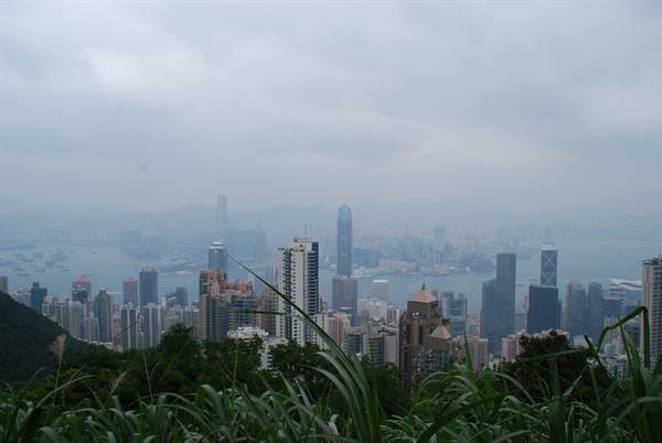 Hong Kong skyscrapers in haze from Victoria Peak, grass in foreground