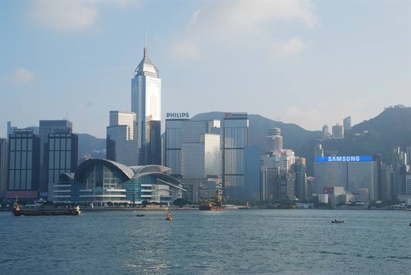 Hong Kong skyscrapers and Convention Centre across the harbour with small boats