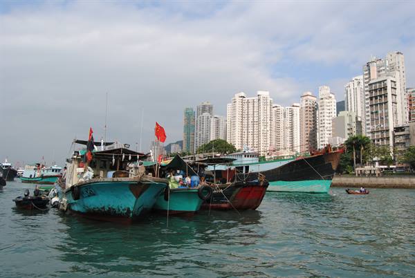 Wooden fishing boats moored in the harbor, Hong Kong skyscrapers in the background