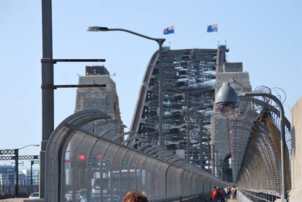 Pedonati recintati salgono verso il mastio in acciaio del Sydney Harbour Bridge