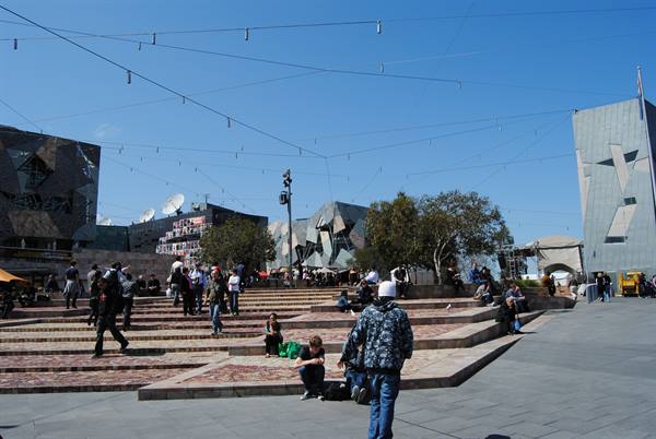 Federation Square di Melbourne, gente seduta sulle gradinate in mattoni