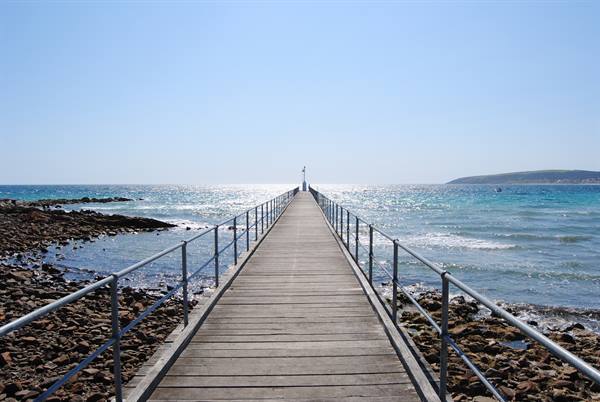 Ponte di legno sul mare a Victor Harbour, scogli e luce intensa