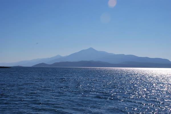 Sparkling sea under blue sky in front of Mount Athos