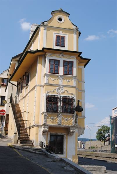 Yellow baroque corner house with outdoor stairs and wrought iron grilles, Bratislava