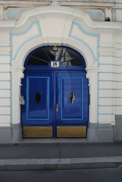 Blue double door numbered 16, white and light blue baroque frame