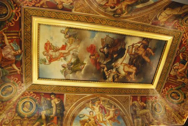 Mythological ceiling fresco with golden frame, crowded figures in the light
