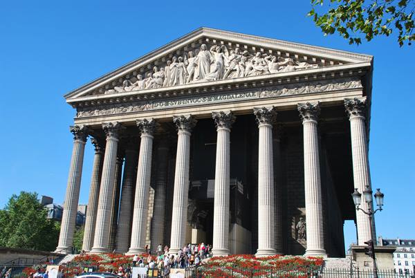 La Madeleine in Paris, Corinthian columns and sculpted pediment under blue sky