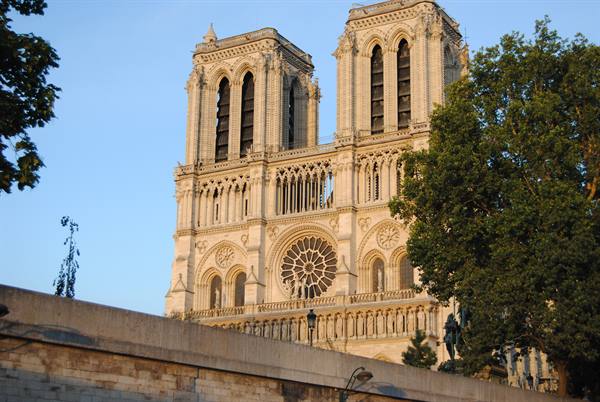 Gothic facade of Notre-Dame in Paris with rose window and twin towers, evening light