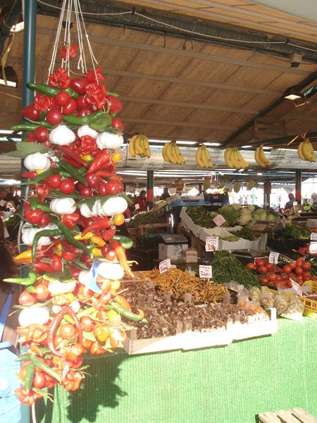 Market stall with hanging peppers, garlic and tomatoes braids