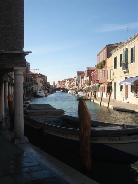 Moored boat along a canal lined with colorful houses, morning light