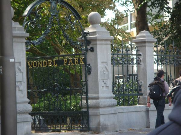 Wrought iron Vondelpark gate with golden lettering, passerby with backpack