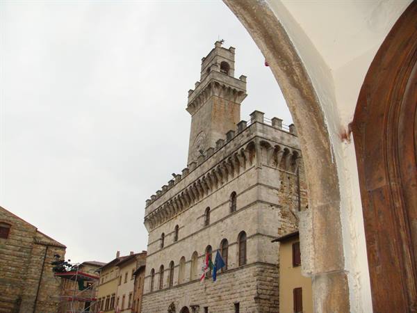 Montepulciano's town hall tower framed by a stone arch