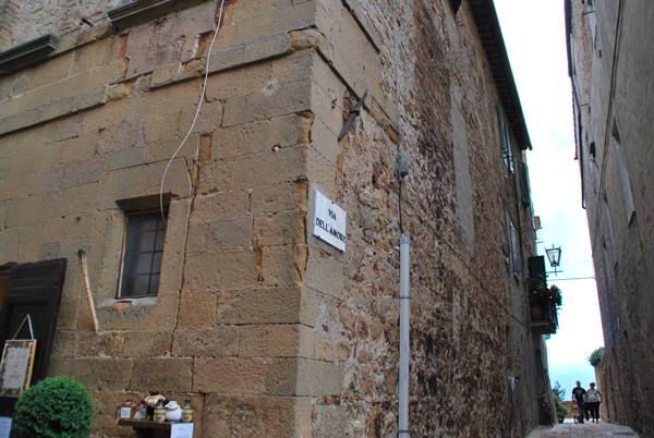 Stone corner with Via dell'Amore street sign, narrow uphill alley