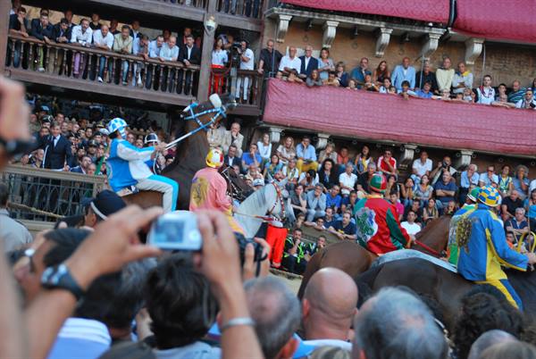 Horses and jockeys at Siena's Palio among the cheering crowd