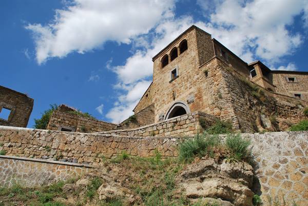 Civita di Bagnoregio, tuff stone houses under a blue cloudy sky