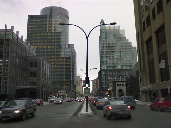 Traffic on McGill College Avenue in Montreal, glass towers under grey sky