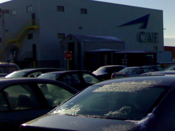 Cars with snow on windshields in the lot outside the CAE building
