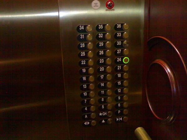 Golden metal elevator panel, floor 24 button glowing green