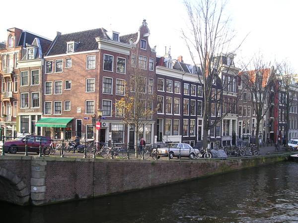 Brick canal houses in Amsterdam, bicycles parked along the bridge
