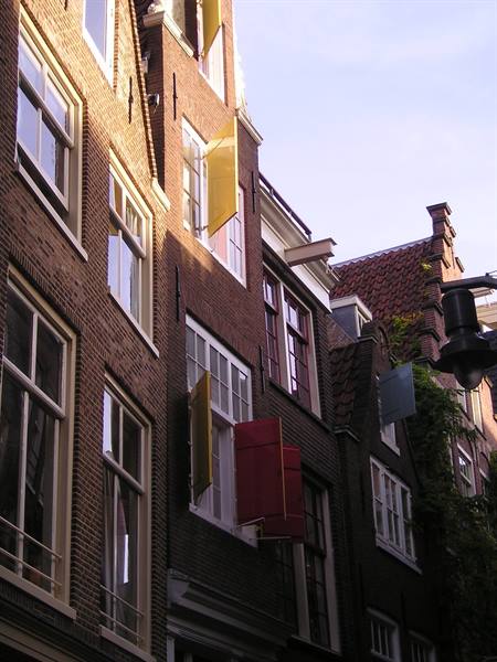 Amsterdam brick facades with yellow and red shutters in morning light