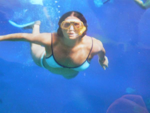 Woman in yellow snorkel mask and blue bikini swimming underwater