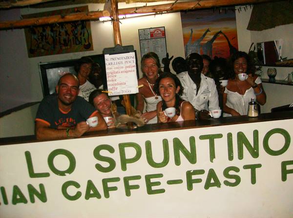 Smiling tourists with coffee cups at the Lo Spuntino café counter