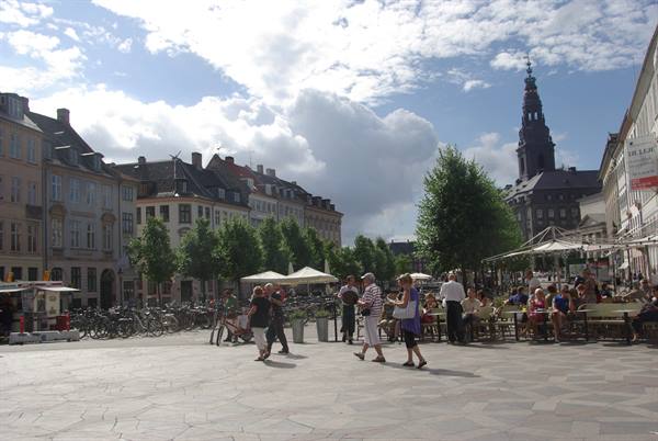Copenhagen square with outdoor cafés, parked bicycles and Christiansborg tower
