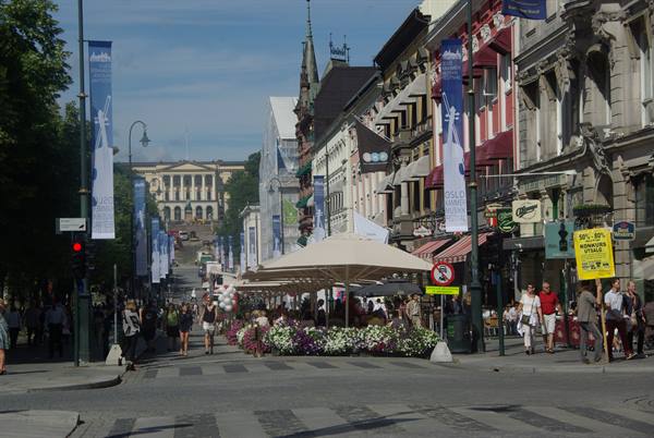 Karl Johans gate in Oslo, pedestrians and café umbrellas facing the royal palace