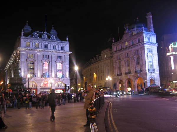 Piccadilly Circus at night: illuminated buildings, crowds, neon lights glowing