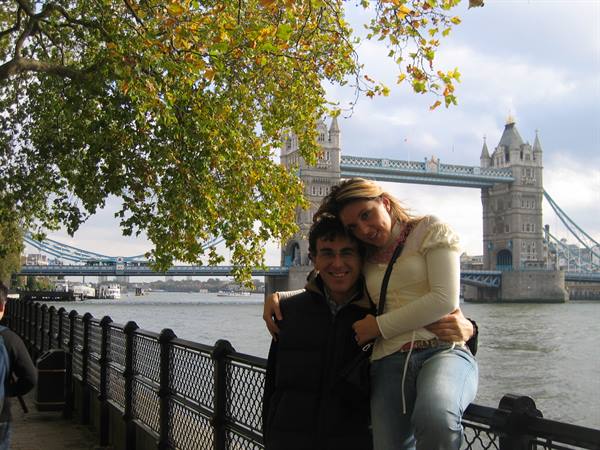 Couple embracing by the Thames with Tower Bridge behind, soft autumn daylight