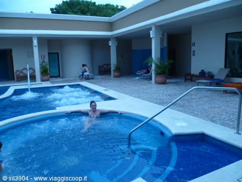 Woman relaxing in the resort pool's jacuzzi at dusk