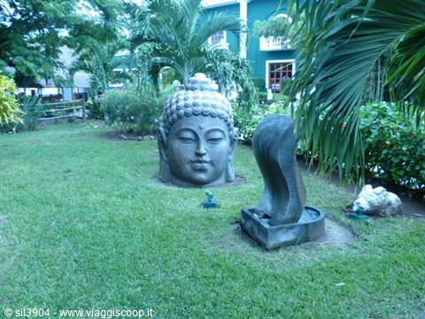 Stone Buddha head among palm trees in a hotel garden